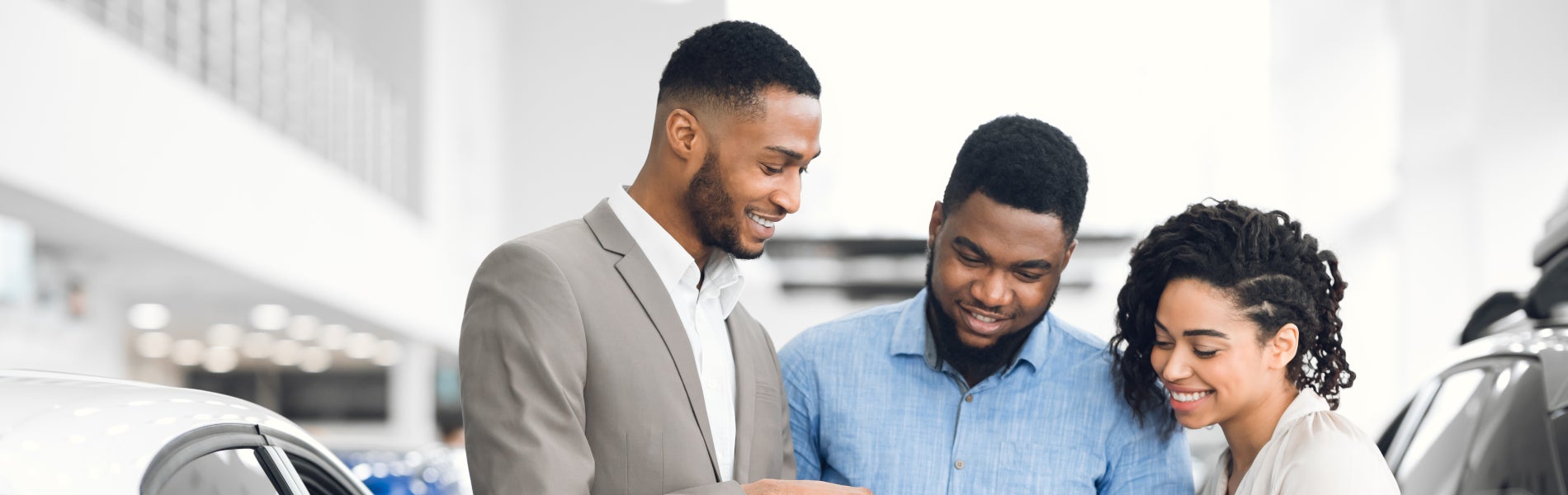 Dealership employee showing a couple a finances inside the dealership